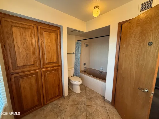 an empty room with a chandelier fan and closet