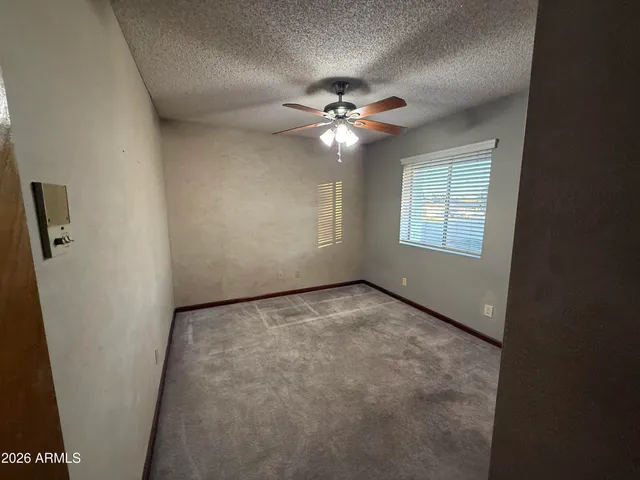 an empty room with a ceiling fan and a window