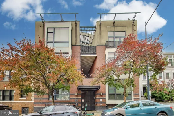 a front view of a building with large tree
