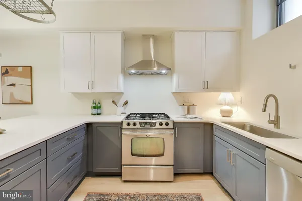 a kitchen with a stove sink and cabinets