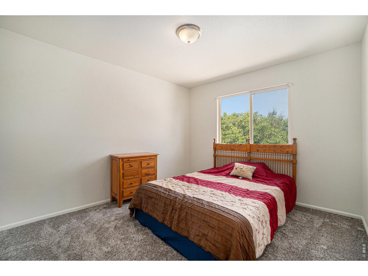 11226 Dover Street Firestone, CO 80504 - Photo 12 of 27 a bed sitting in a bedroom next to a window