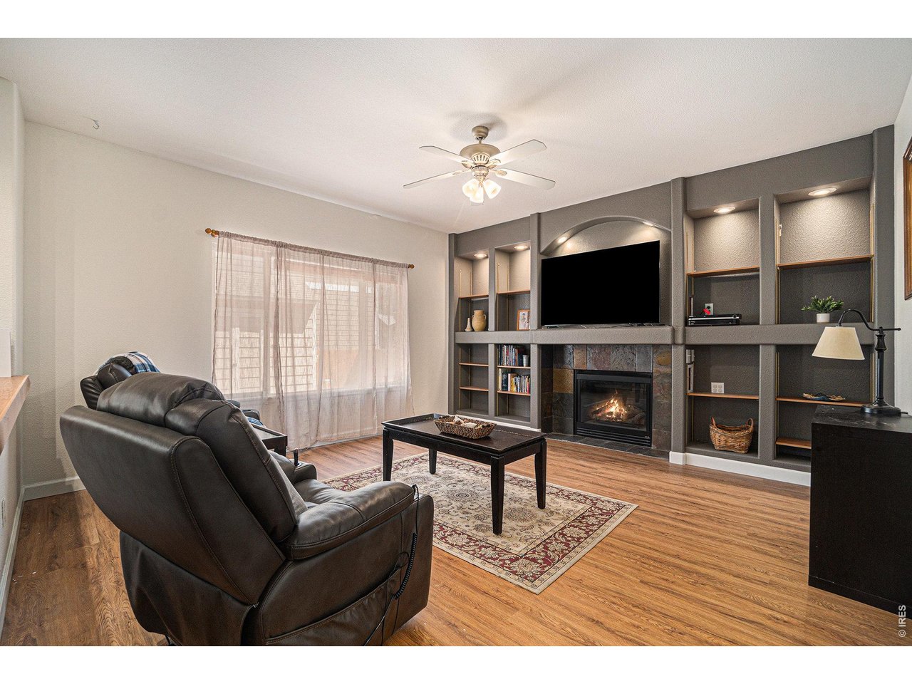 11226 Dover Street Firestone, CO 80504 - Photo 9 of 27 a living room with furniture a fireplace and a flat screen tv