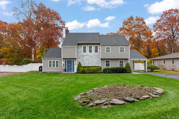 a front view of a house with a garden and trees