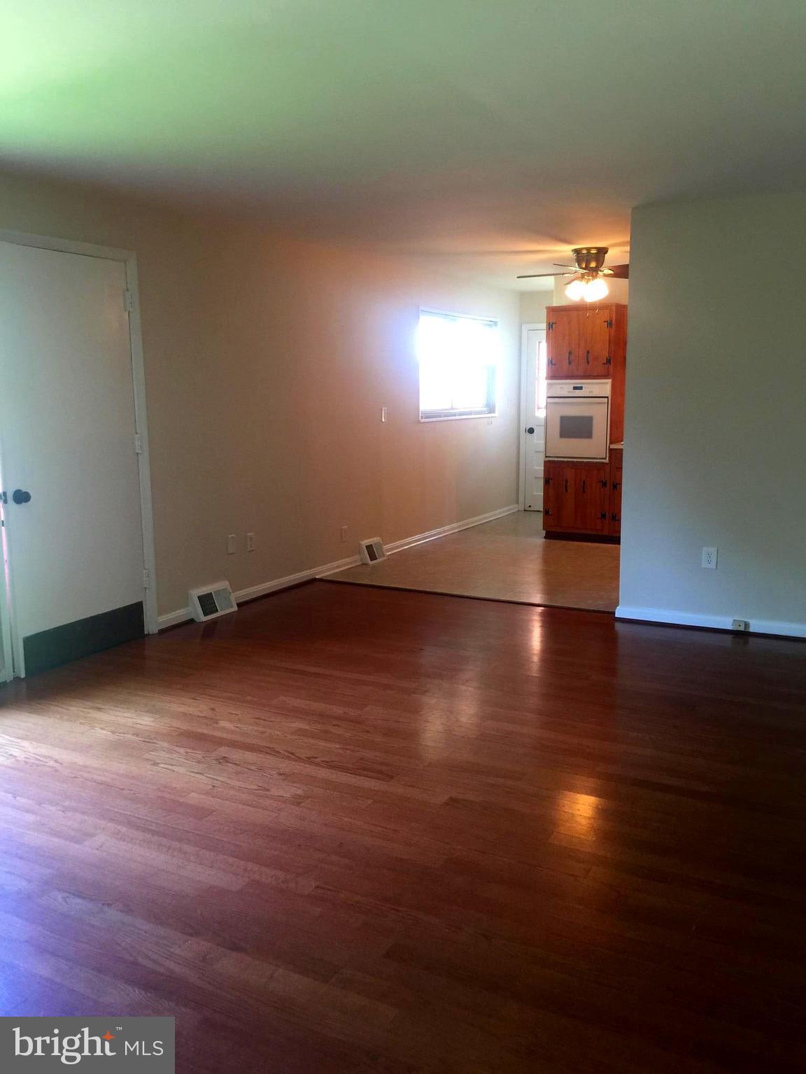 1605 West 7th Street Frederick, MD 21702 - Photo 6 of 19 an empty room with wooden floor and windows