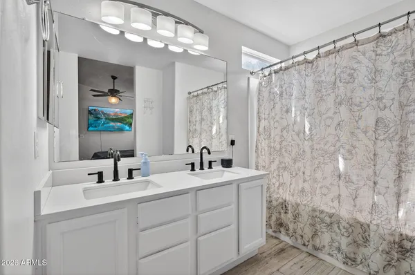 a bathroom with a double vanity sink mirror and shower