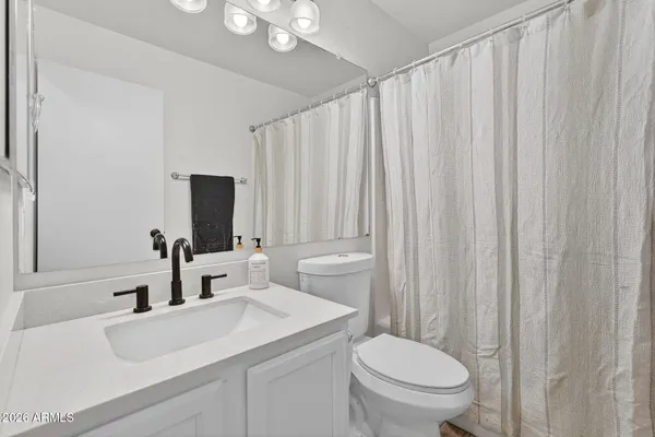 a bathroom with a toilet a sink and a mirror