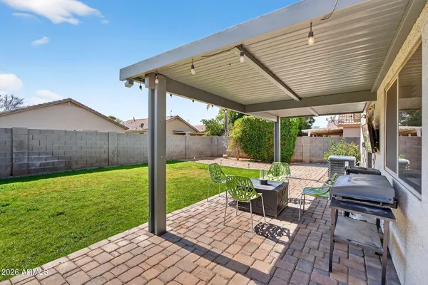 a view of a patio with wooden table and chairs