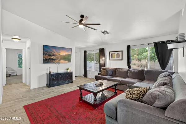 a living room with furniture a window and a flat screen tv