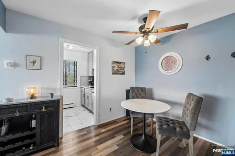 a view of a dining room with furniture a chandelier and wooden floor