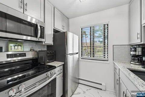 a kitchen with stainless steel appliances a stove a microwave and a refrigerator