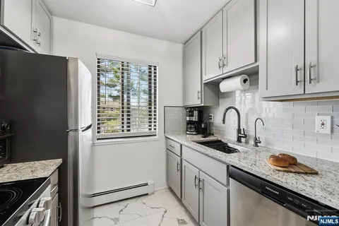 a kitchen with granite countertop a sink stove and refrigerator