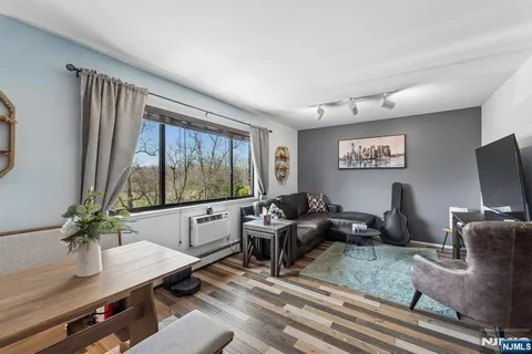 a living room with furniture flat screen tv and a large window