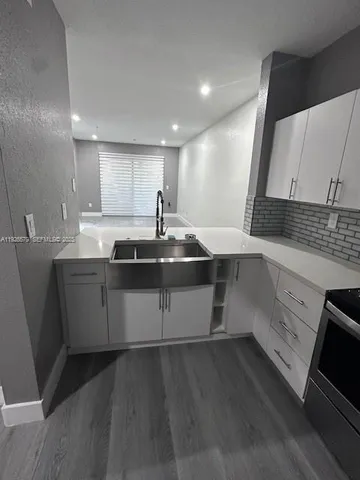 a kitchen with a sink appliances and cabinets
