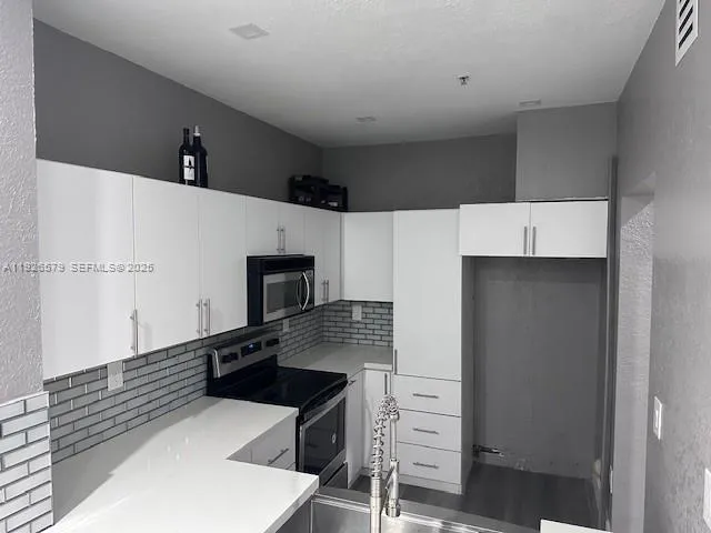a kitchen with stainless steel appliances a refrigerator and a stove top oven