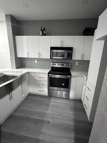 a kitchen with stainless steel appliances a stove a sink and a microwave
