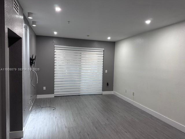 7100 Northwest 177th Street, Unit 100 Hialeah, FL 33015 - Photo 4 of 13 an empty room with wooden floor and entrance