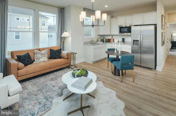 a kitchen with stainless steel appliances granite countertop a refrigerator a sink a stove and white cabinets
