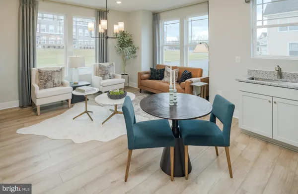 a kitchen with stainless steel appliances a dining table chairs microwave and refrigerator