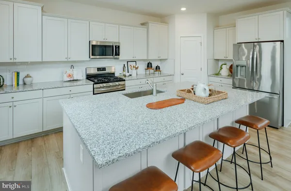 a kitchen with stainless steel appliances granite countertop a stove a sink and a white cabinets
