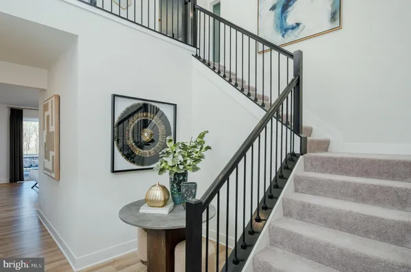 a view of a hallway with wooden floor and stairs