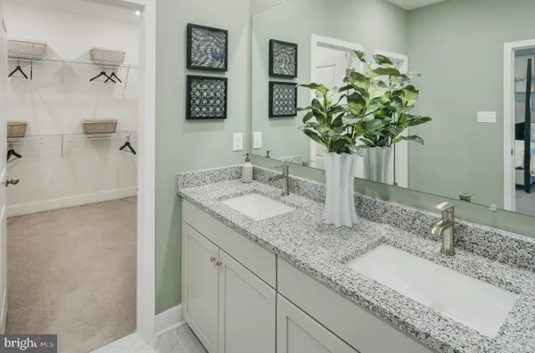 a bathroom with a granite countertop sink a mirror and a shower