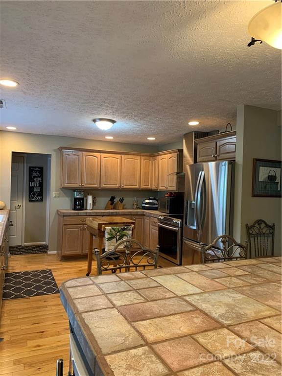 1115 Gouges Branch Road Leicester, NC 28748 - Photo 12 of 48 a large kitchen with stainless steel appliances kitchen island granite countertop a refrigerator and a sink