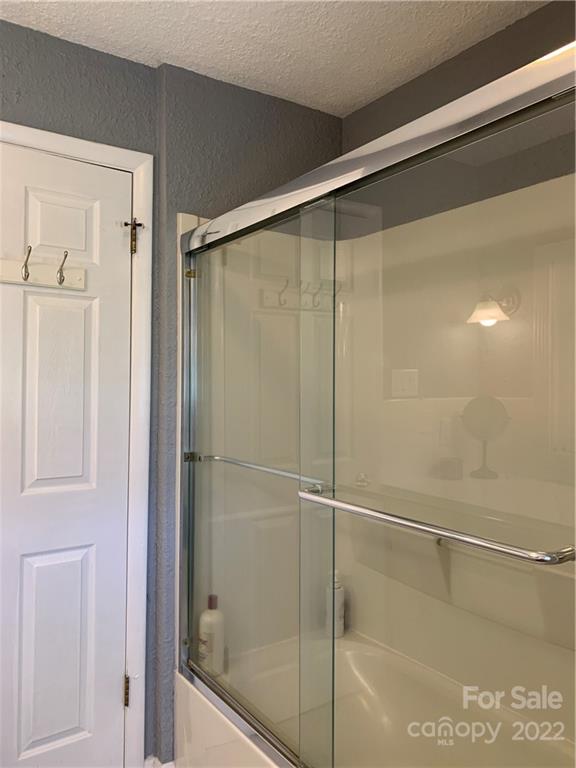 1115 Gouges Branch Road Leicester, NC 28748 - Photo 26 of 48 a bathroom with a glass shower door