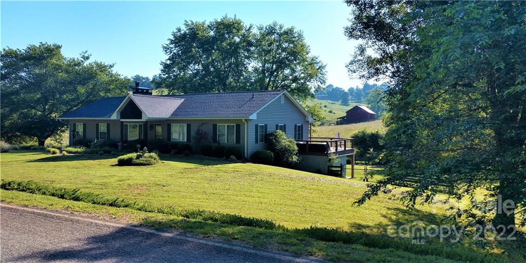 1115 Gouges Branch Road Leicester, NC 28748 - Photo 38 of 48 a view of house with yard outdoor seating and covered with trees