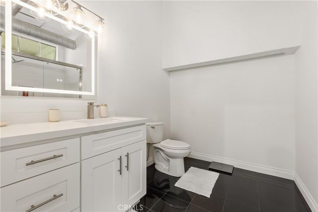 a view of a brick house with large windows and a tree