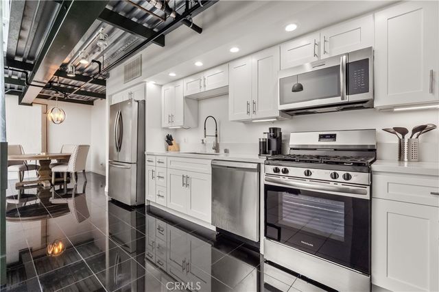 a kitchen with stainless steel appliances a stove sink and microwave