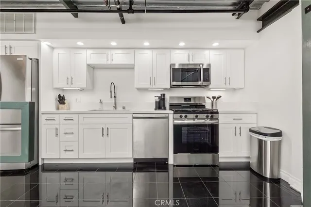 a kitchen with white cabinets and sink