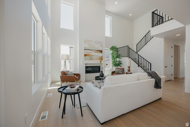 5902 Canyon Rim Road, Unit 620 Lehi, UT 84048 - Photo 30 of 78 Two-story living area featuring a fireplace with a white surround, large windows, and light wood-finish flooring