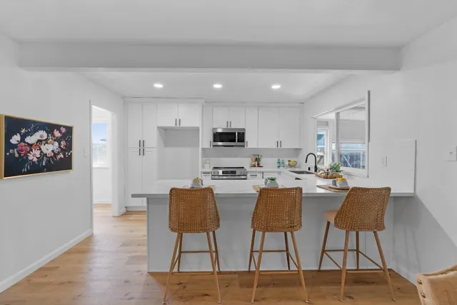 a kitchen with a refrigerator a stove a sink dishwasher with a dining table and chairs