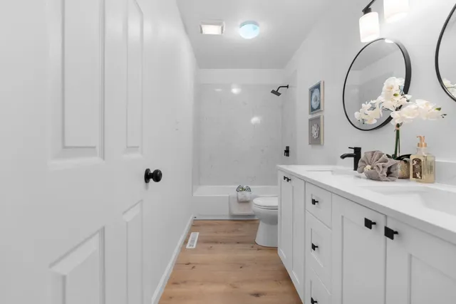 a bathroom with a double vanity sink mirror and toilet
