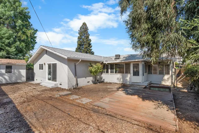 a white house with tree in front of it