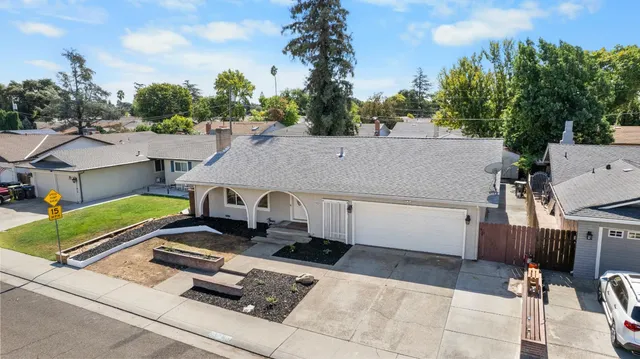 a front view of a house with cars parked