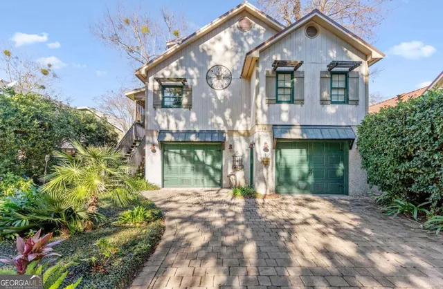 a front view of a house with a yard and potted plants