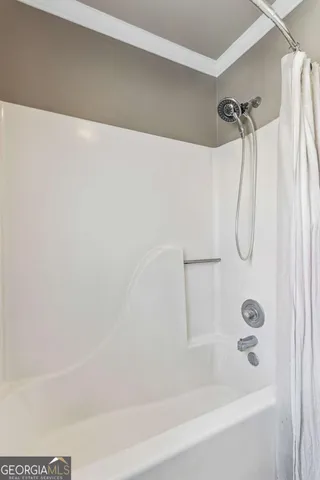 a bathroom with a bath tub with a shower