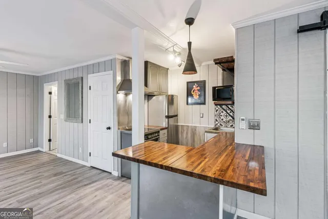 a room with kitchen island a wooden floor and refrigerator