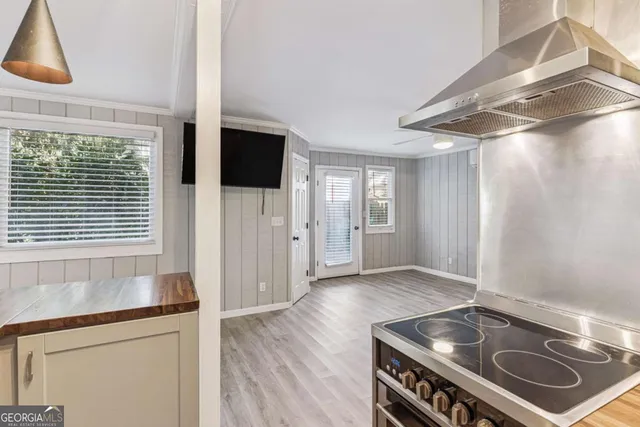 a kitchen that has a stove and a wooden floor