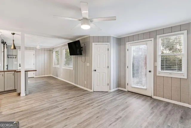 a view of a livingroom with wooden floor and a ceiling fan
