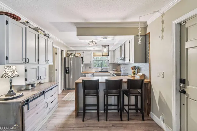 a large kitchen with cabinets table and chairs