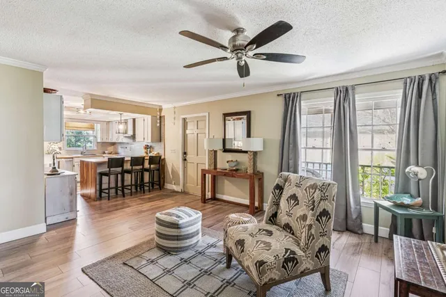 a living room with furniture and a large window with wooden floor