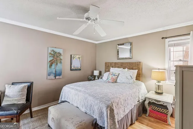 a bedroom with a bed a painting on the wall and a dresser