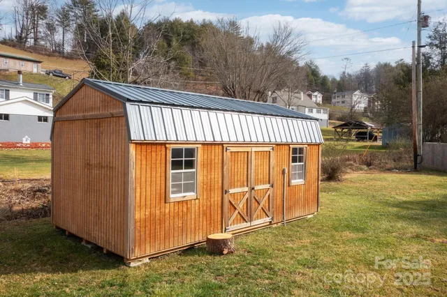 a view of a house with backyard and wooden fence