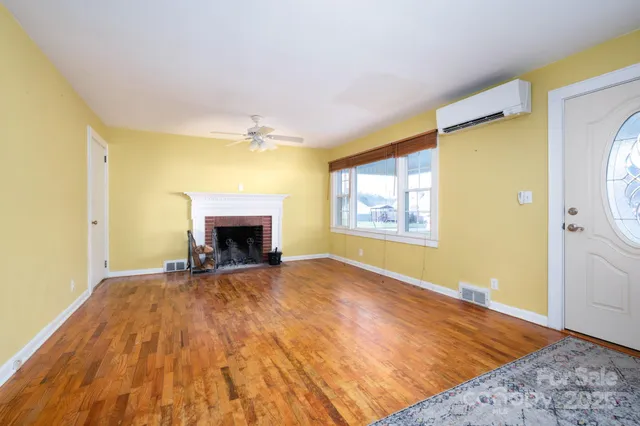 a view of an empty room with a fireplace and a window