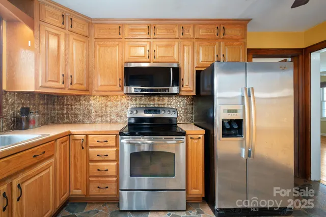 a kitchen with stainless steel appliances granite countertop a refrigerator stove and microwave
