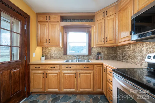 a kitchen with granite countertop a sink and a stove
