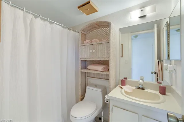 a bathroom with a sink a toilet and shower curtain