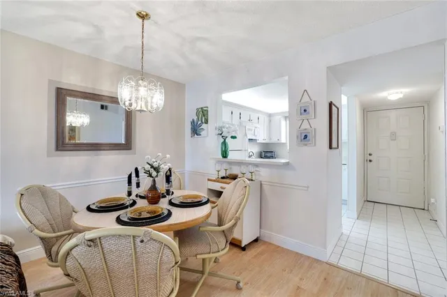 a kitchen with stainless steel appliances a dining table chairs and white cabinets